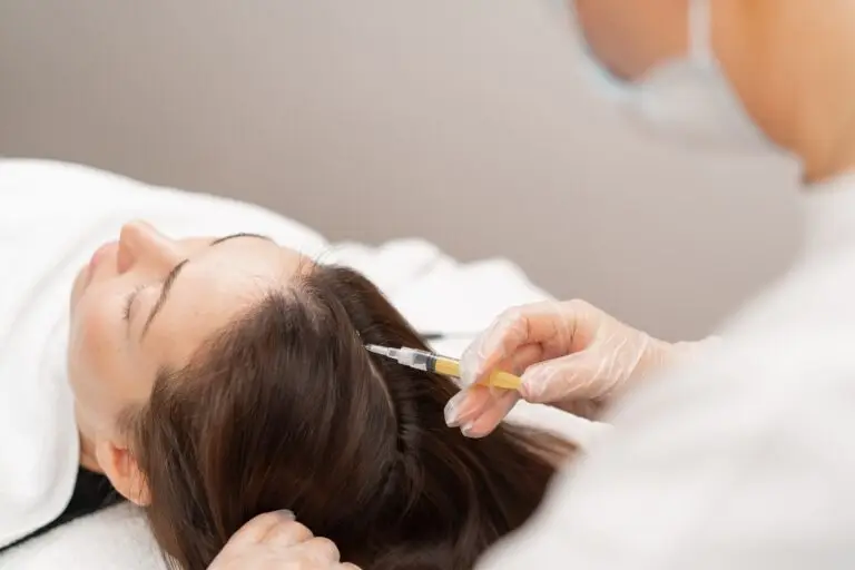 A beautician makes injections into the scalp for hair growth Mesotherapy for hair growth